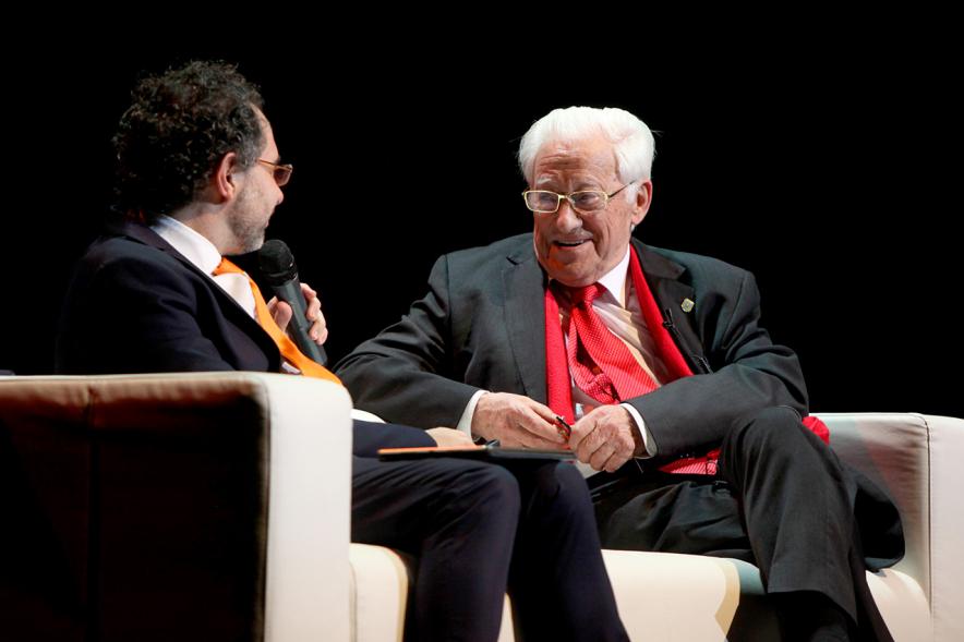 Gala Homenaje a la Solidaridad - Imagen del escenario, donde están sentados en un sofá charlando el mago More y el padre Ángel.