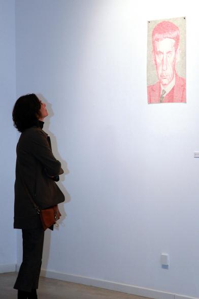 Inauguración Exposición de Gonzalo Elvira "12 Canciones Concretas" - Imagen de persona mirando los cuadros de la exposición.