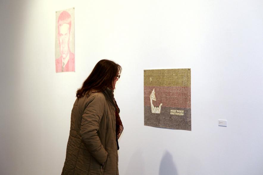 Inauguración Exposición de Gonzalo Elvira "12 Canciones Concretas" - Imagen de persona mirando los cuadros de la exposición.