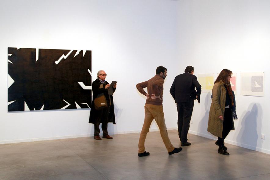 Inauguración Exposición de Gonzalo Elvira "12 Canciones Concretas" - Imagen de personas mirando los cuadros de la exposición.