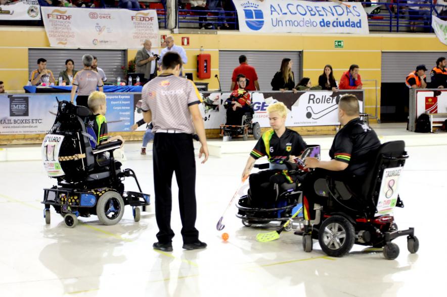 Campeonato de España de Hockey Silla de Ruedas Eléctricas - Imagen del partido con dos jugadores y el árbitro.