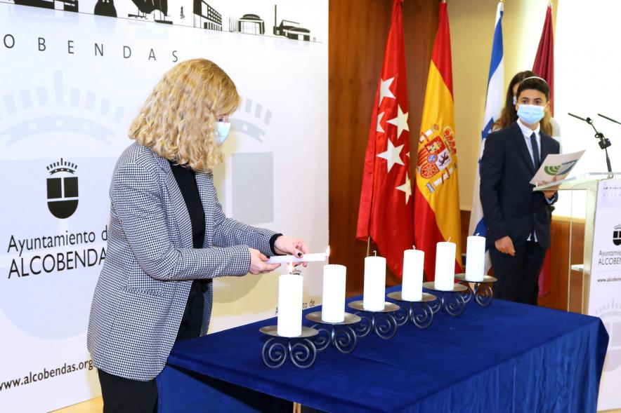 Homenaje a las Víctimas del Holocausto -Imagen del momento que una de las invitadas está encendiendo una de las seis velas.