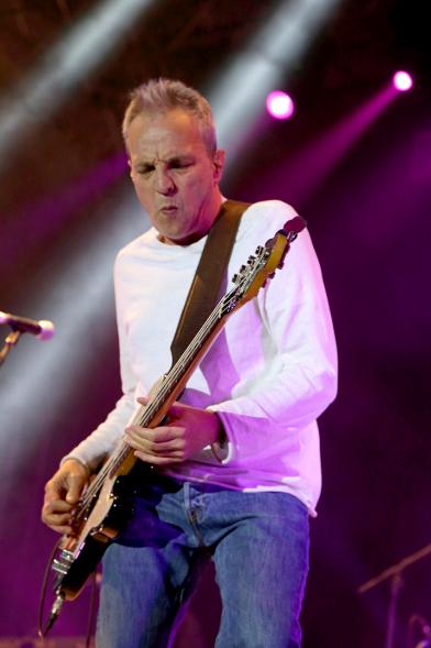 Cantante con guitarra bajo focos morados
