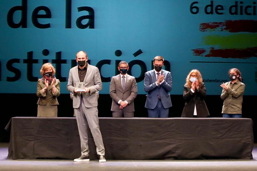 Homenaje a Servicios Esenciales y Voluntarios - Imagen de uno de los homenajeados recogiendo su premio y las autoridades que los entregan.