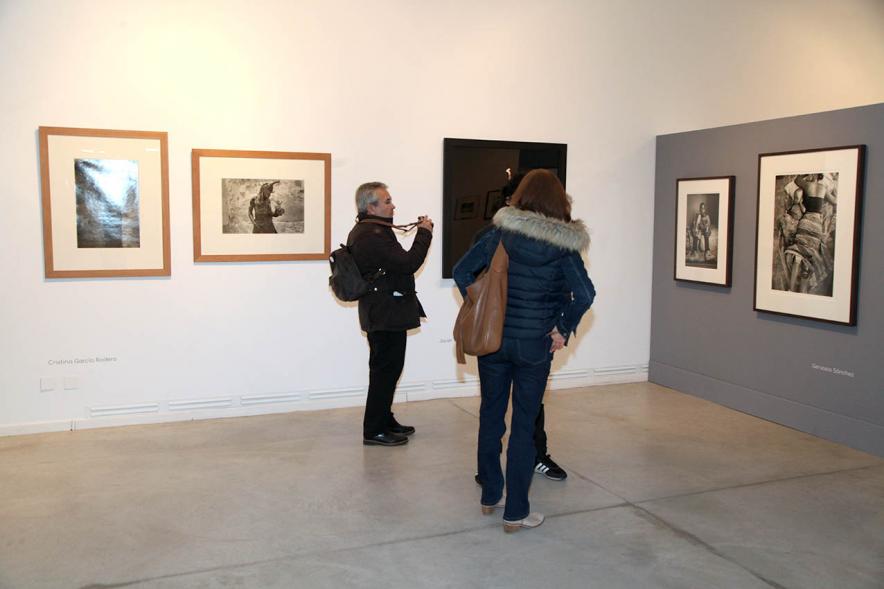 Asistentes al evento mirando fotografías de la colección – 2020