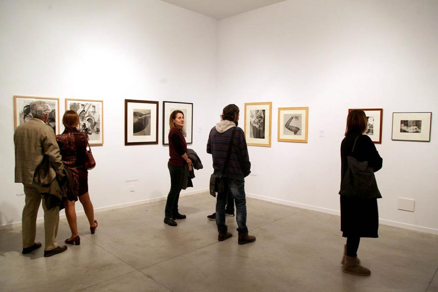 Asistentes al evento mirando fotografías de la colección – 2020