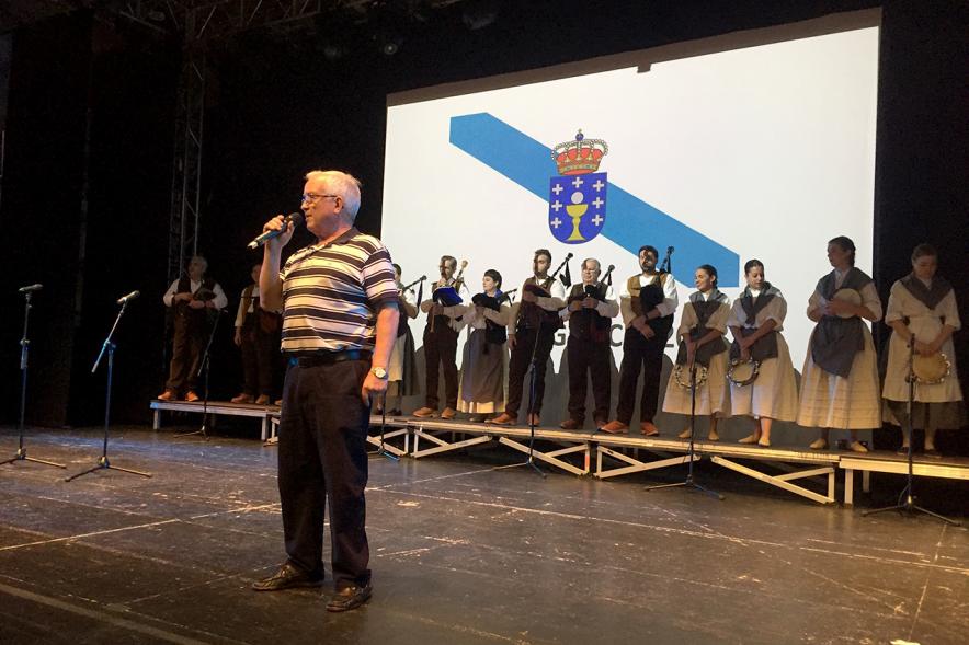 Día de Galicia 2018 - Primer plano del presentador y el grupo musical detrás.