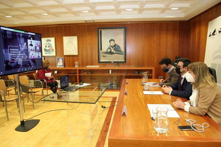 Presentación 2ª Convocatoria de la Plataforma de Innovación abierta colaborativa StartUp Alcobendas - Imagen donde vemos la mesa que preside esta presentación y en la pantalla vemos a los participantes en una videoconferencia. 