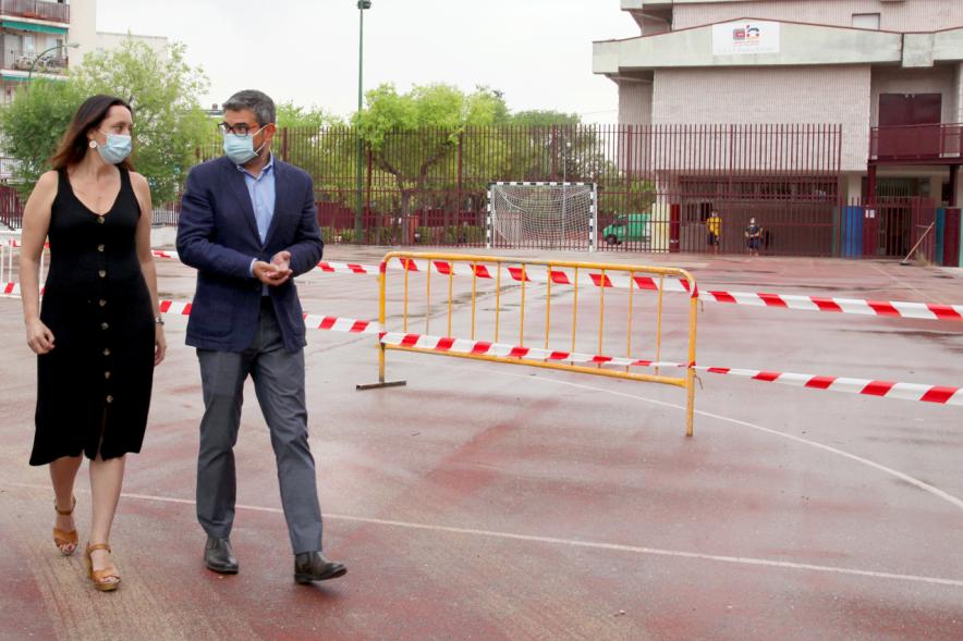 Sánchez Acera caminando por el patio del colegio con representante de este