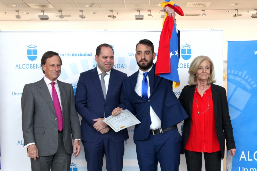 Alcalde García de Vinuesa y Concejal por PP Felicidad Palacio entregan diploma a su titular, que emocionado levanta una bandera venezolana