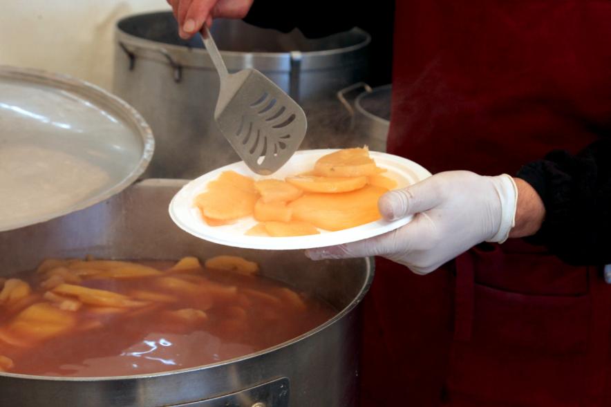 Inauguración XXIª Romería del Pulpo y el Mejillón - Imagen de persona poniendo patatas en un plato.