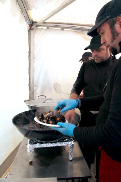 Inauguración XXIª Romería del Pulpo y el Mejillón - Imagen de persona colocando unos mejillones en un plato.