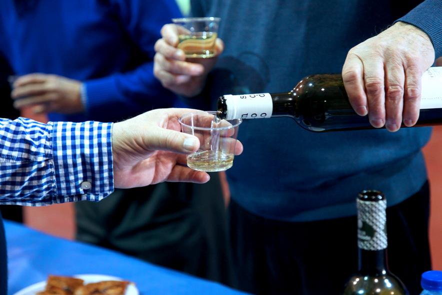 Inauguración XXIª Romería del Pulpo y el Mejillón - Imagen de personas sirviéndose vino blanco.