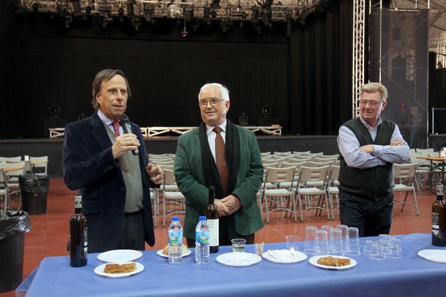 Inauguración XXIª Romería del Pulpo y el Mejillón - Imagen del alcalde García de Vinuesa y otras personas probando la comida que hay en la mesa.