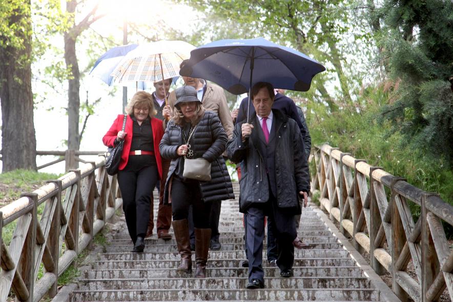 Miembros del consistorio bajando escalera en medio de la lluvia