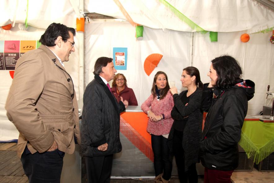 Miembros del ayuntamiento charlando con ciudadanos en una caseta