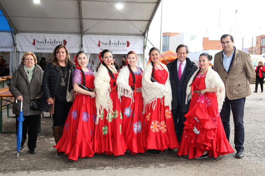 Delegación municipal posa con bailarinas en traje regional frente a caseta de Castillo León