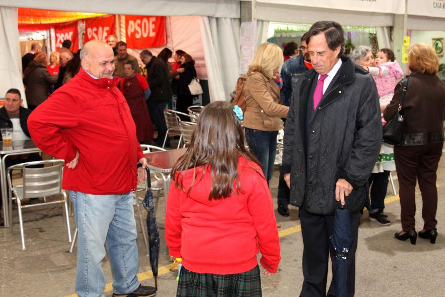 Alcalde García de Vinuesa charlando con una niña y su abuela frente a la caseta de PSOE