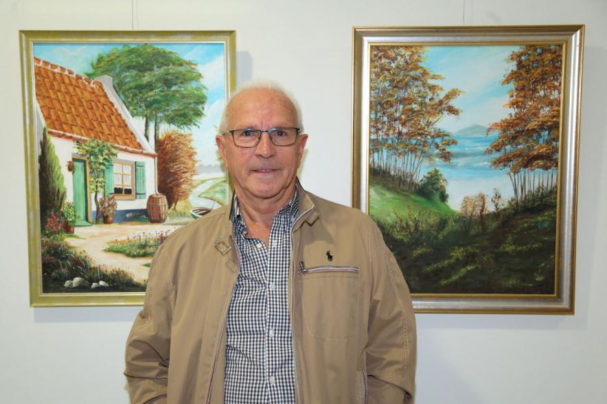 Artista entre dos de sus obras. 2019