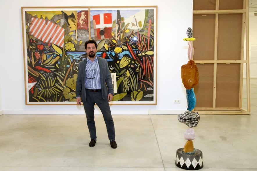 Inauguración de las Exposiciones "El camino Indicado" de Eduardo Barco y "Cocodrilos en la Pista - Estudio para una pieza Camp" de Miki Leal - Posado de Miki Leal junto a una de sus obras mural.