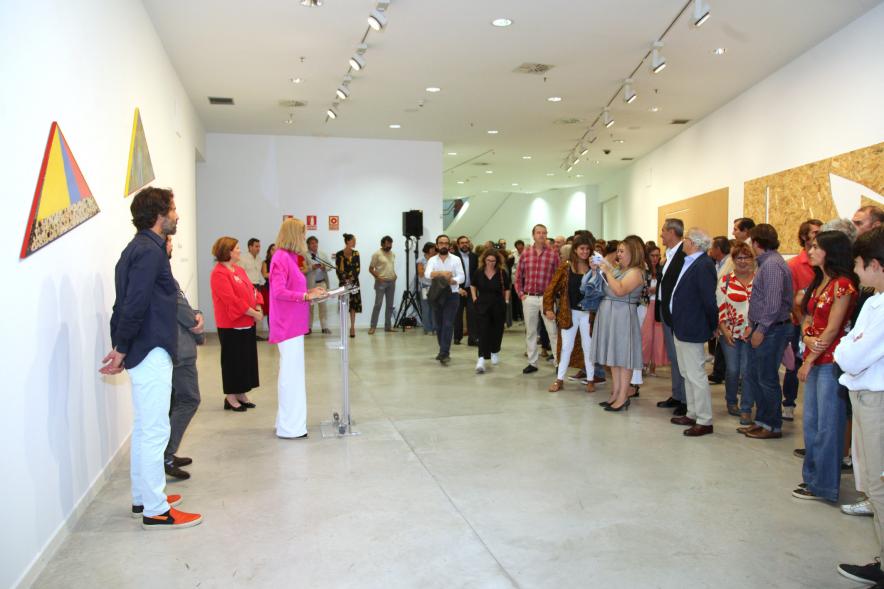 Inauguración de las Exposiciones "El camino Indicado" de Eduardo Barco y "Cocodrilos en la Pista - Estudio para una pieza Camp" de Miki Leal - Plano abierto de los asistentes a la exposición junto a la presentadora y los dos artistas.