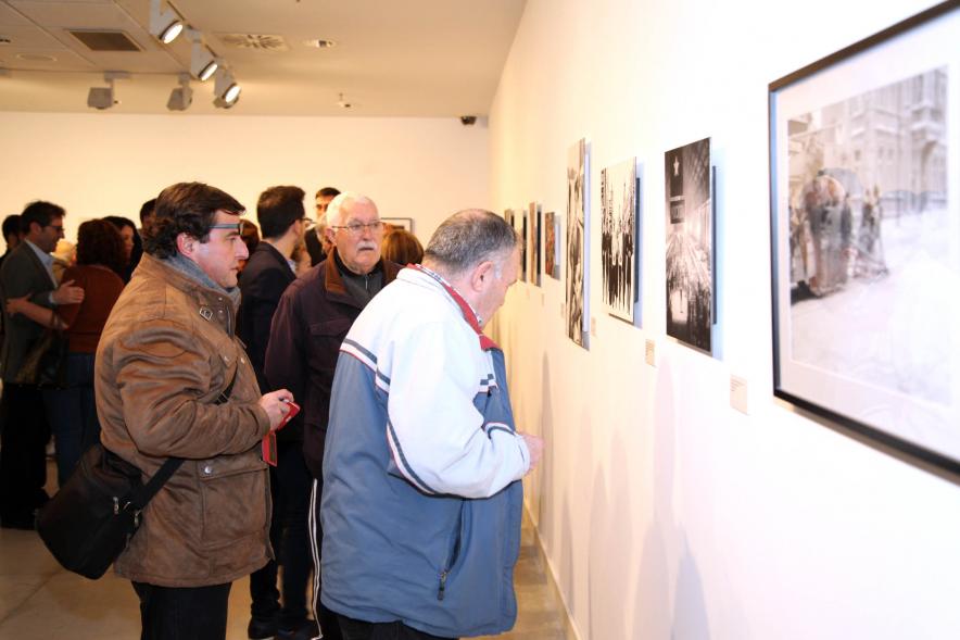 Asistentes al evento mirando fotografías de la colección - 2020
