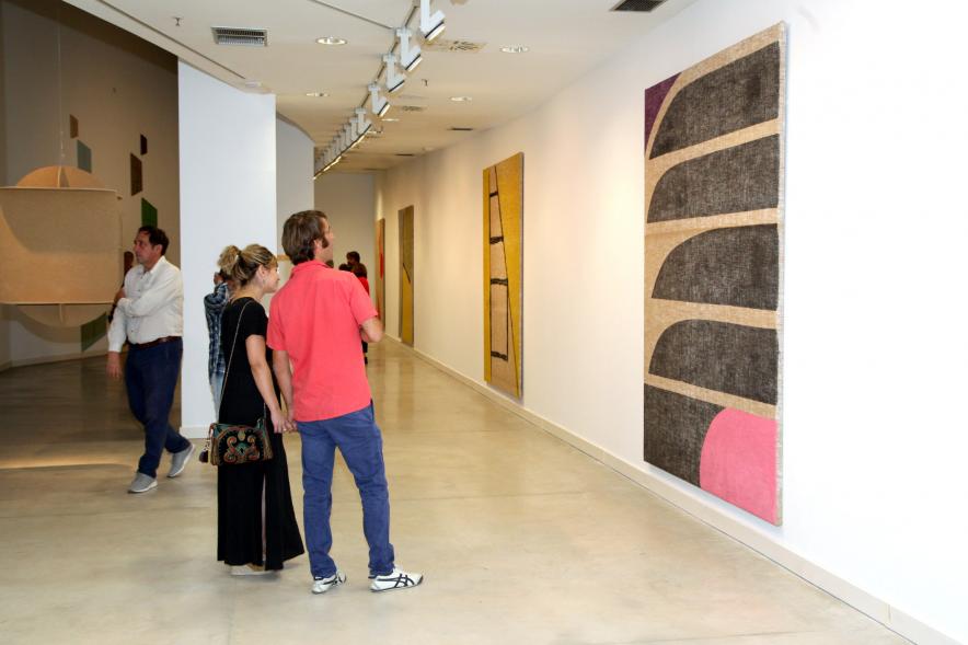 Inauguración de las Exposiciones "El camino Indicado" de Eduardo Barco y "Cocodrilos en la Pista - Estudio para una pieza Camp" de Miki Leal - Imagen de varios asistentes contemplando varios cuadros.