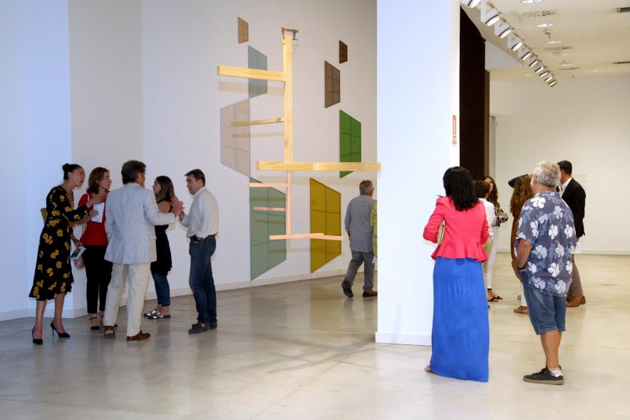 Inauguración de las Exposiciones "El camino Indicado" de Eduardo Barco y "Cocodrilos en la Pista - Estudio para una pieza Camp" de Miki Leal -  Imagen de los  asistentes contemplando un mural muy colorido. 