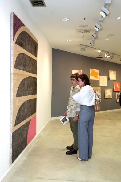 Inauguración de las Exposiciones "El camino Indicado" de Eduardo Barco y "Cocodrilos en la Pista - Estudio para una pieza Camp" de Miki Leal -  Imagen de los  asistentes contemplando un mural muy colorido. 