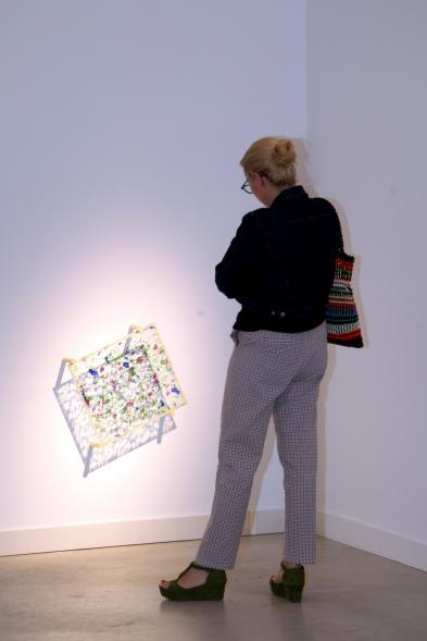 Inauguración de las Exposiciones "El camino Indicado" de Eduardo Barco y "Cocodrilos en la Pista - Estudio para una pieza Camp" de Miki Leal - Primer plano de una obra en 3D y una visitante.