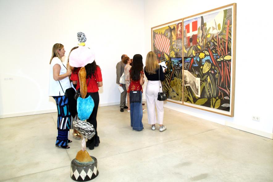 Inauguración de las Exposiciones "El camino Indicado" de Eduardo Barco y "Cocodrilos en la Pista - Estudio para una pieza Camp" de Miki Leal - Imagen de los  asistentes contemplando un mural muy colorido. 