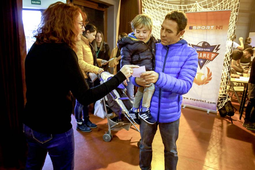 Fiesta Celebración Día Internacional de los Derechos de la Infancia - Imagen una familia recogiendo  un programa a la entrada del evento.
