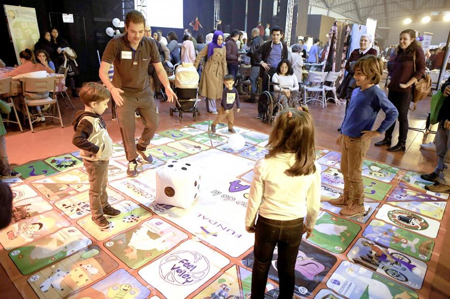 Fiesta Celebración Día Internacional de los Derechos de la Infancia - Imagen de un monitor jugando con unos niños a un juego.