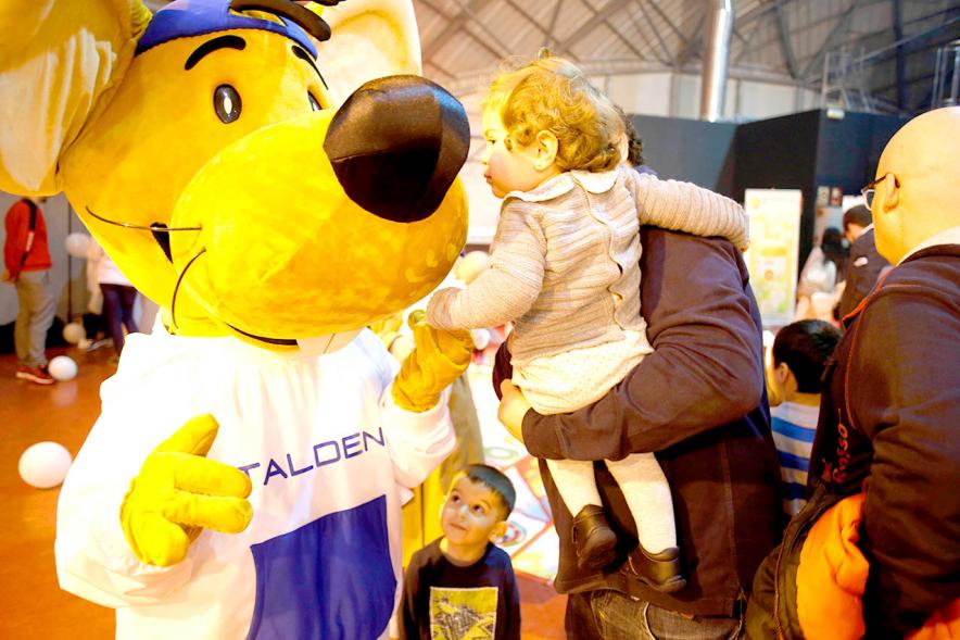 Fiesta Celebración Día Internacional de los Derechos de la Infancia - Imagen de bebe saludando a una mascota que participa en el evento.