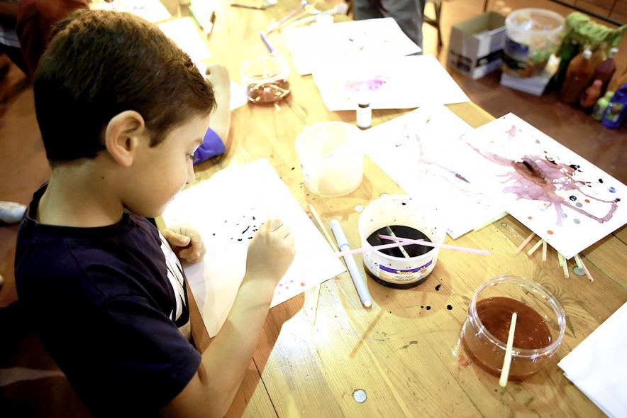 Fiesta Celebración Día Internacional de los Derechos de la Infancia - Imagen de un niño dibujando con acuarelas en un stand.