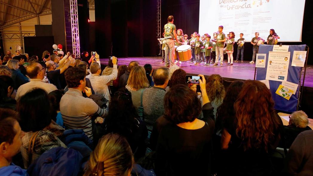 Fiesta Celebración Día Internacional de los Derechos de la Infancia - Imagen de un monitor y unos niños realizando un taller de música en el escenario.