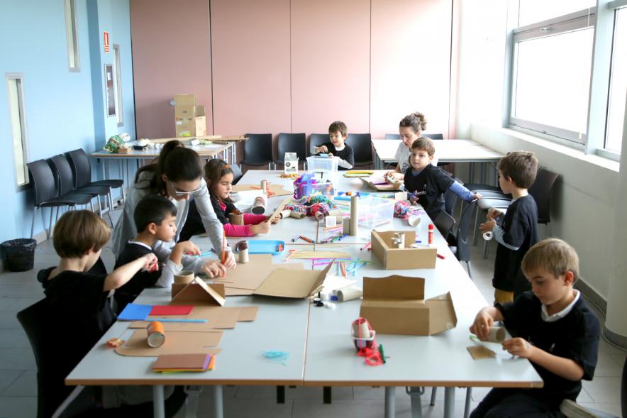 Día de la Nueva Participación Los Influyentes - Imagen de los niños haciendo manualidades junto a la monitora.