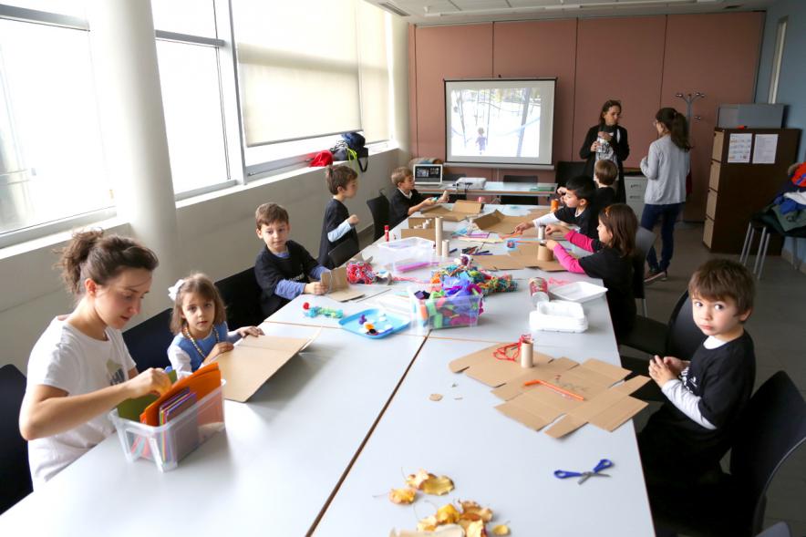 Día de la Nueva Participación Los Influyentes - Panorámica de la mesa de actividades infantiles con la monitora  y  los niños.