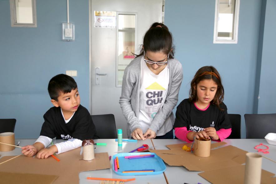 Día de la Nueva Participación Los Influyentes - Imagen de los niños haciendo manualidades junto a la monitora.