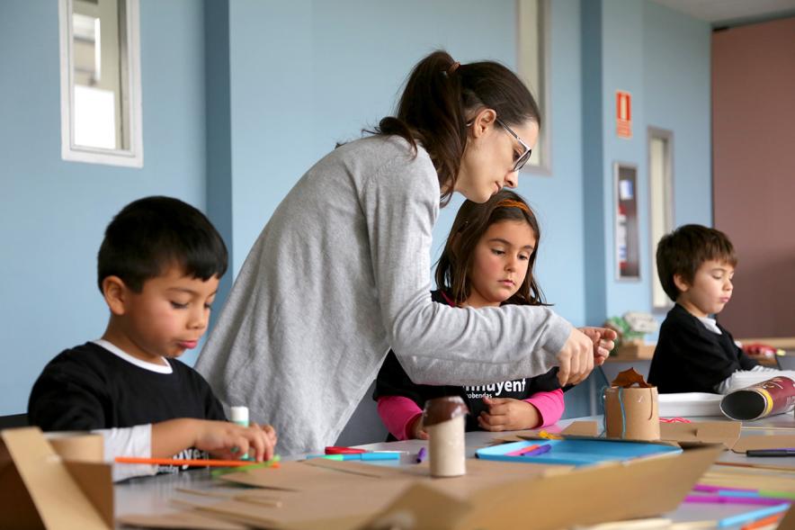 Día de la Nueva Participación Los Influyentes - Primer plano de la monitora ayudando a pintar  a los niños.