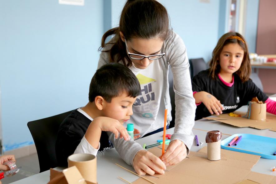 Día de la Nueva Participación Los Influyentes - Primer plano de la monitora ayudando a pintar a un niño.