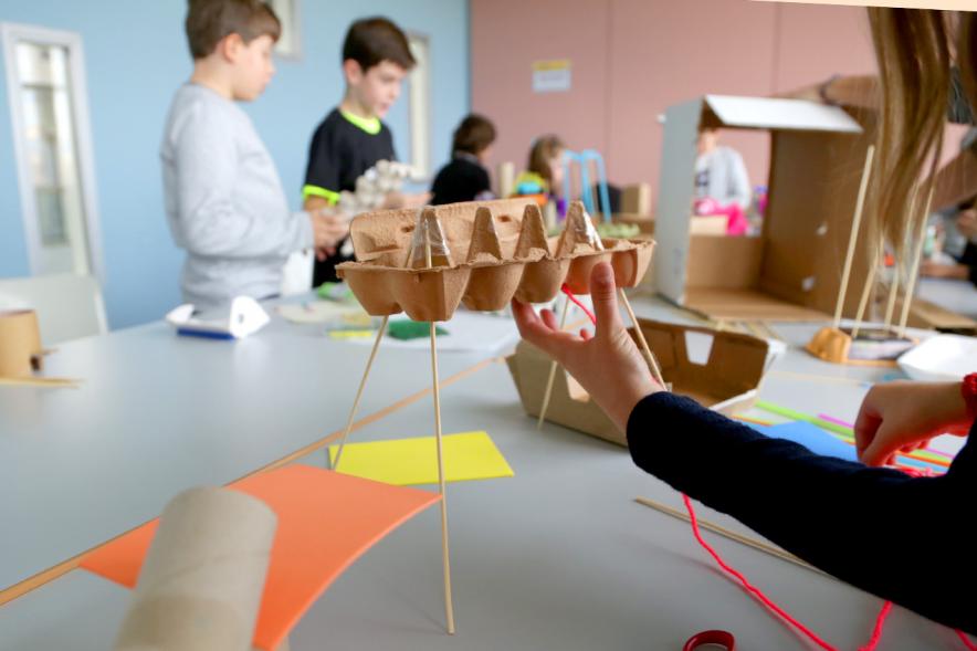 Día de la Nueva Participación Los Influyentes - Primer plano de unas manos infantiles sujetando una manualidad.