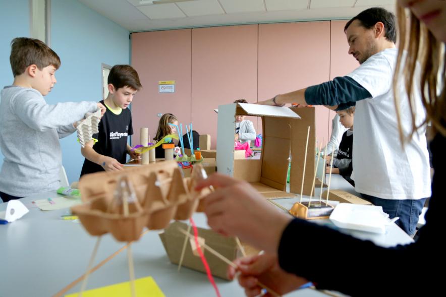Día de la Nueva Participación Los Influyentes - Imagen de los niños haciendo manualidades junto al monitor.