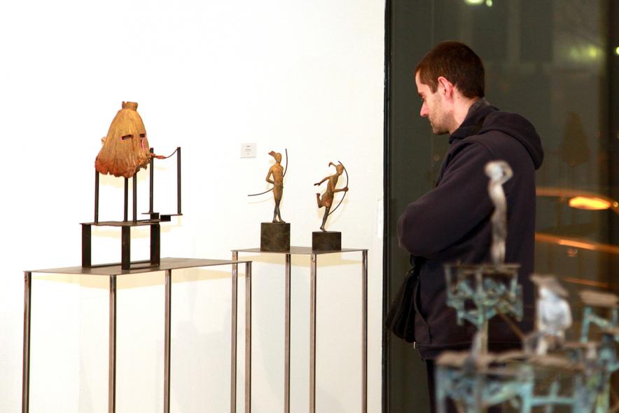 Inauguración Exposición de Escultura "orígenes" de Javier de la Rosa - Imagen persona mirando una de las esculturas de la exposición.