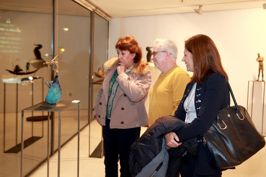 Inauguración Exposición de Escultura "orígenes" de Javier de la Rosa - Imagen personas mirando una de las esculturas de la exposición.