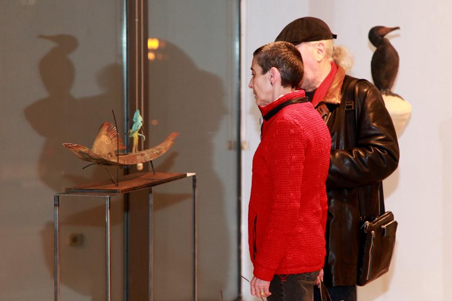 Inauguración Exposición de Escultura "orígenes" de Javier de la Rosa - Imagen personas mirando una de las esculturas de la exposición.