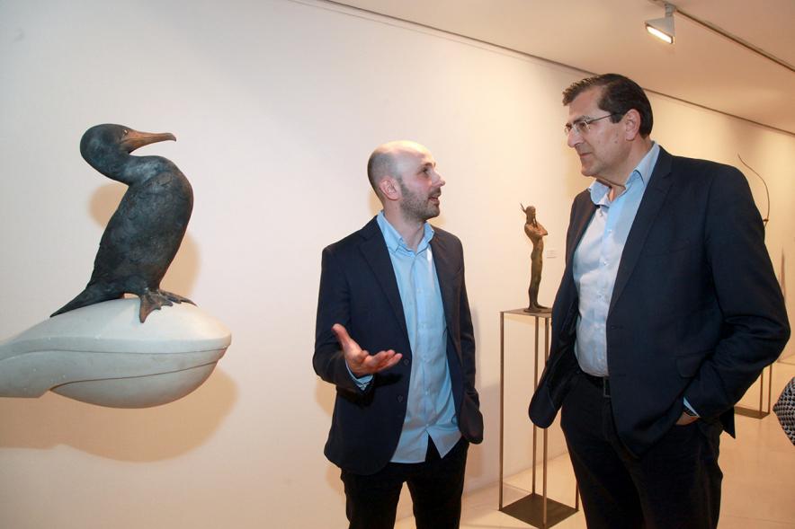 Inauguración Exposición de Escultura "orígenes" de Javier de la Rosa - Imagen del autor de la exposición Javier de la Rosa explicando su obra a una persona.