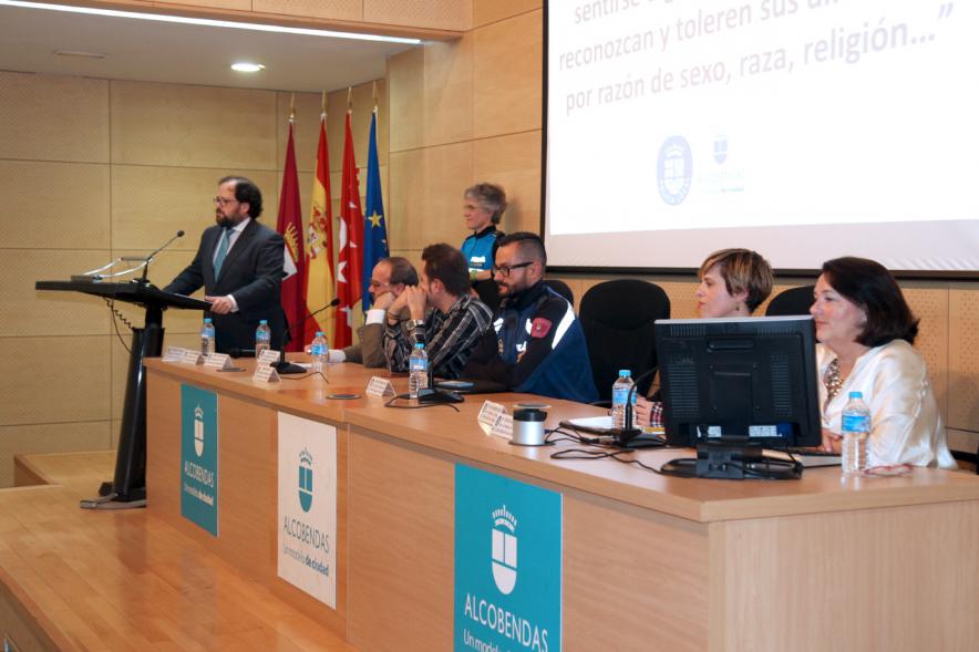 Clausura Jornada "Las Infracciones de Odio" - Imagen panorámica del escenario con una autoridad dirigiéndose al público asistente y los componentes de la mesa de debate.
