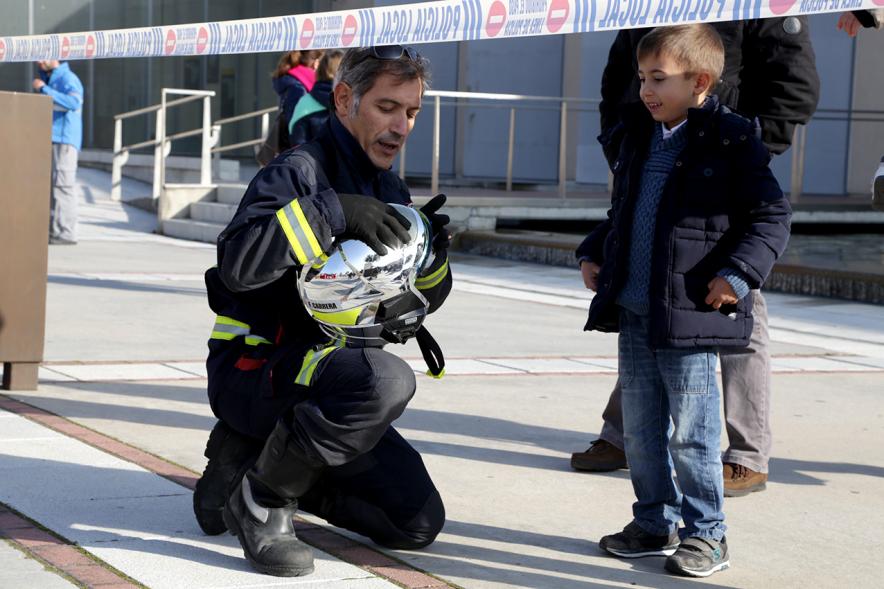 Jornada de Emergencias en Familia - Imagen de un miembro de un cuerpo de seguridad con un niño.