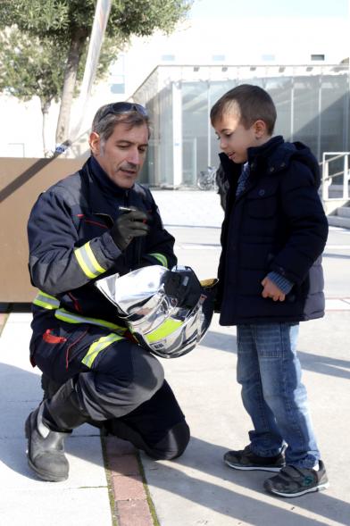 Jornada de Emergencias en Familia - Imagen de un miembro de un cuerpo de seguridad con un niño.